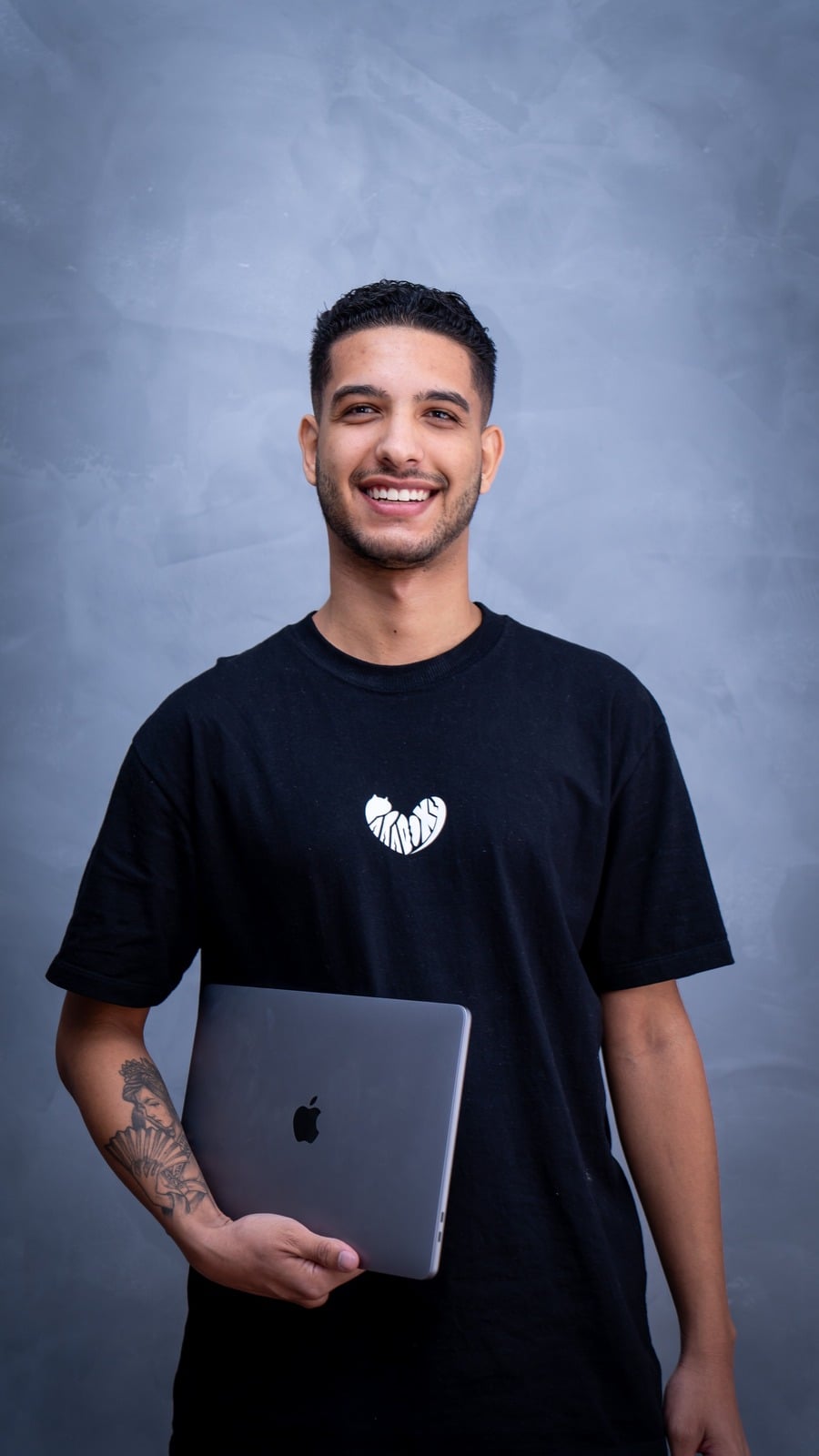 Fernando, videomaker e fotógrafo, segurando um notebook